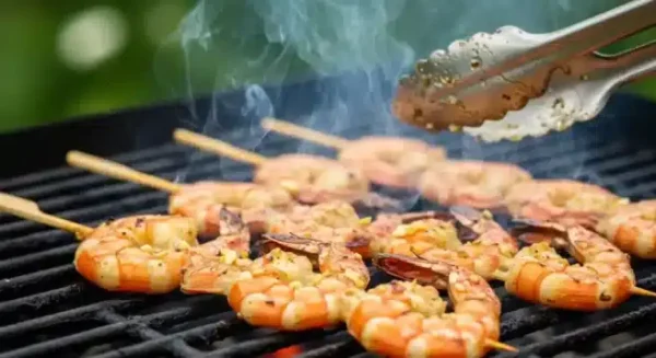 Juicy shrimp skewers grilling over an open flame with garlic butter glaze.