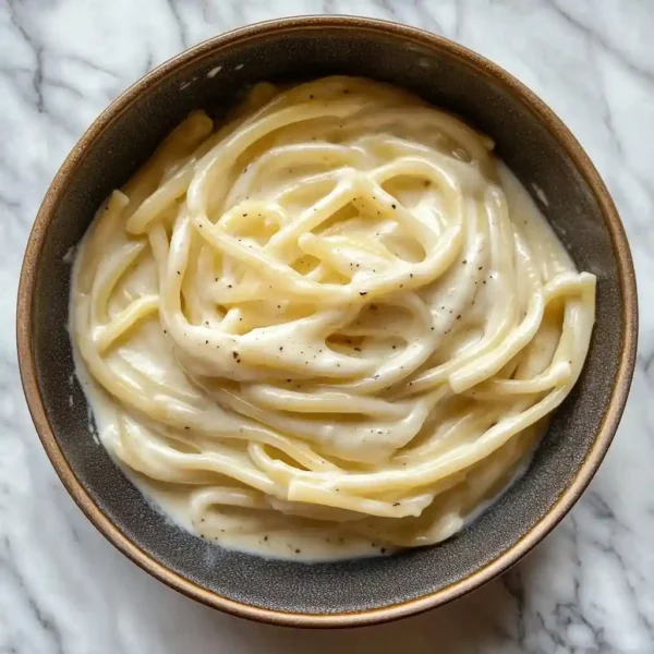 pasta coated with cottage cheese alfredo sauce in a ceramic bowl