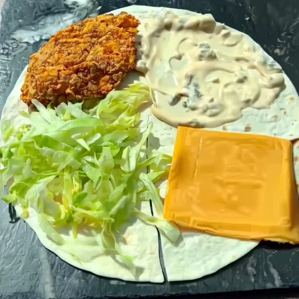 crispy chicken burger folded wrap with cheese, lettuce, sauce and chicken