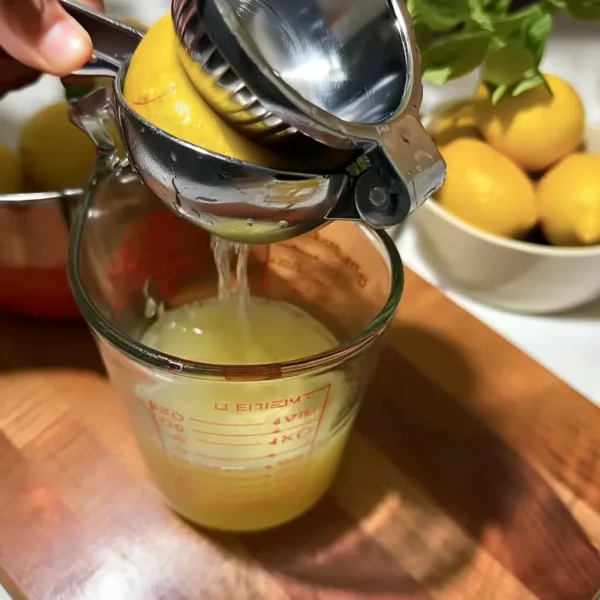strawberry mango lemonade lemon squeezed into glass measuring cup