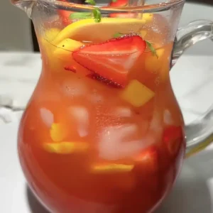 Strawberry Mango Lemonade: Your New Favorite Summer Refreshment strawberry mango lemonade in a clear pitcher with ice, lemon slices, strawberry and mango chunks