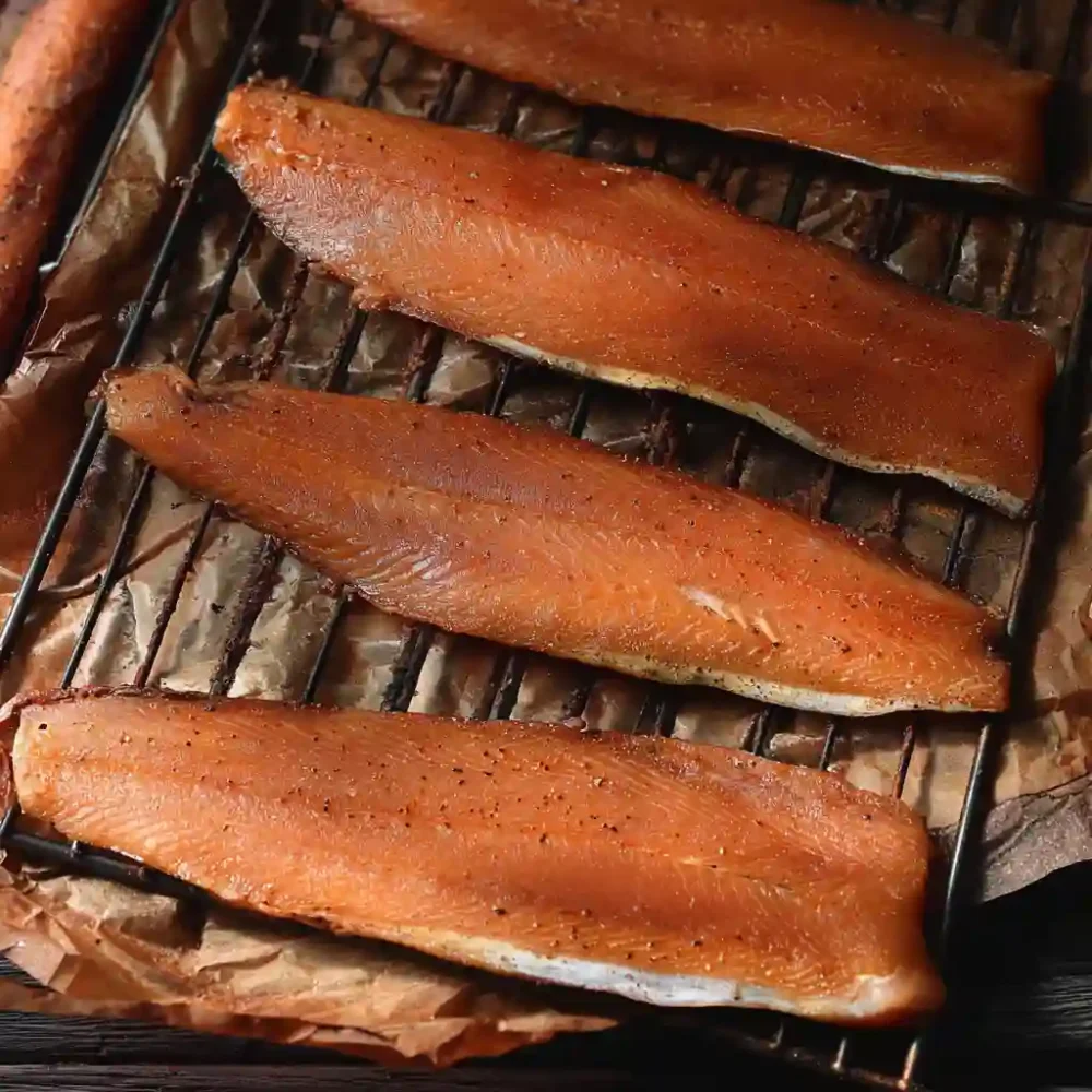 Raw trout fillets drying on rack before cold smoking