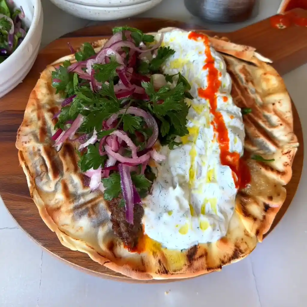 Lebanese Beef Wrap: Easy Kofta-Style Flatbread with Tzatziki Grilled Lebanese beef wrap opened with sauces and toppings
