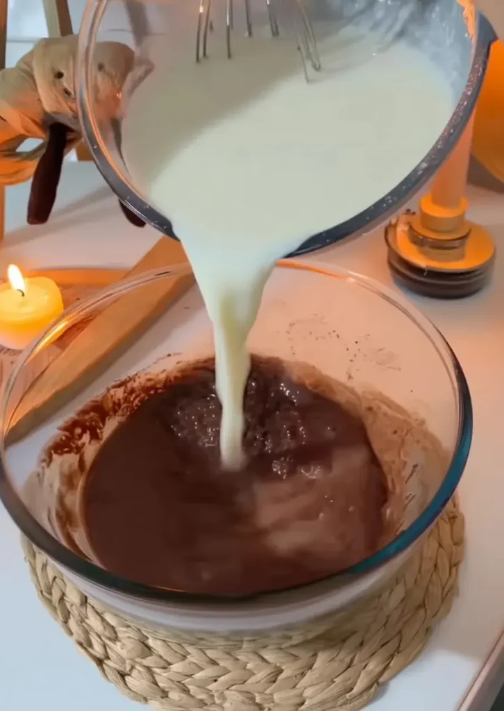 Chocolate Bomboloni – Italian Cream-Filled Delight Pouring warm milk into melted chocolate for Bomboloni filling