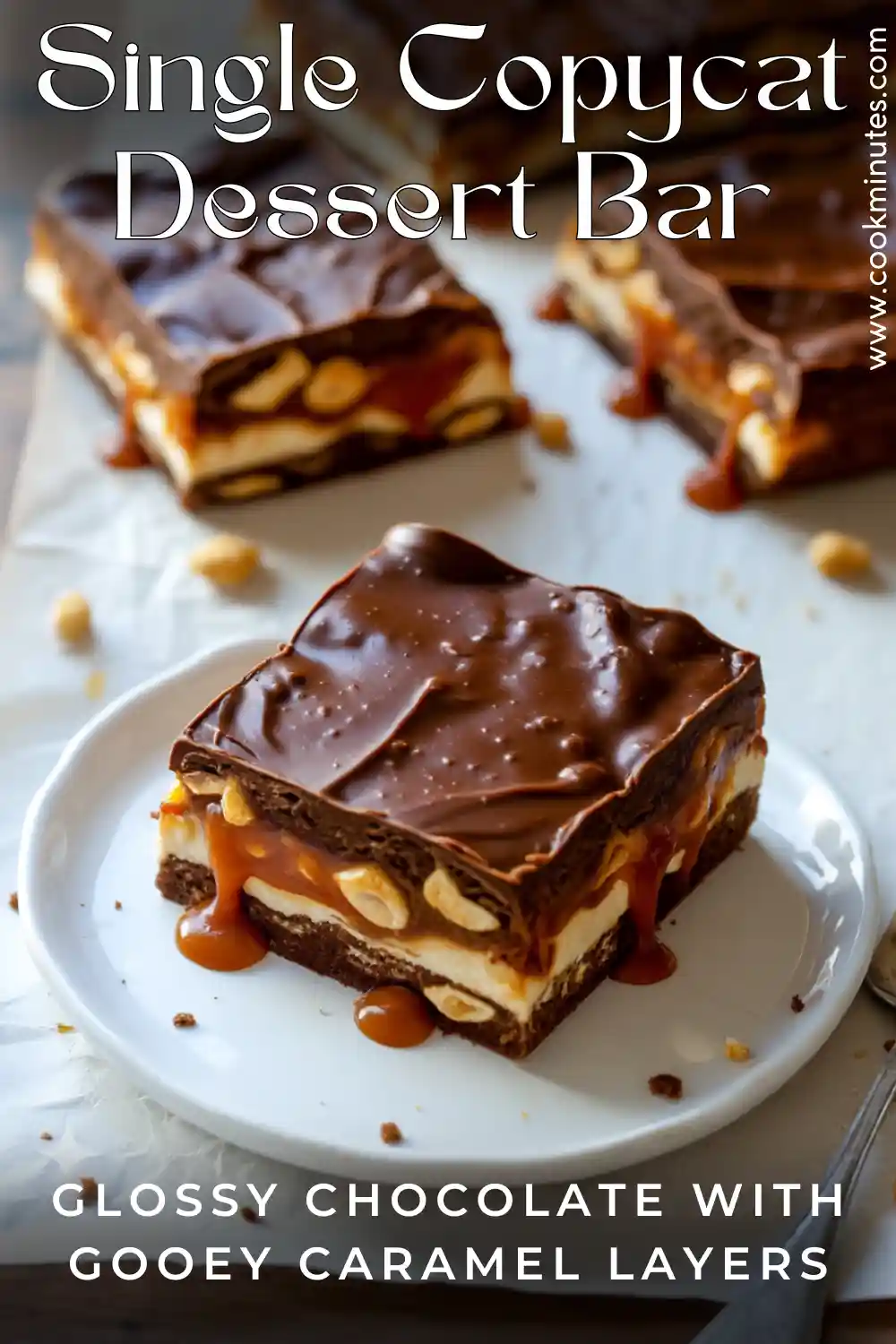 Homemade No Bake Snickers Bars (Copycat Recipe) A single homemade no bake Snickers-style bar on a plate with glossy chocolate, caramel dripping, nougat, and peanuts