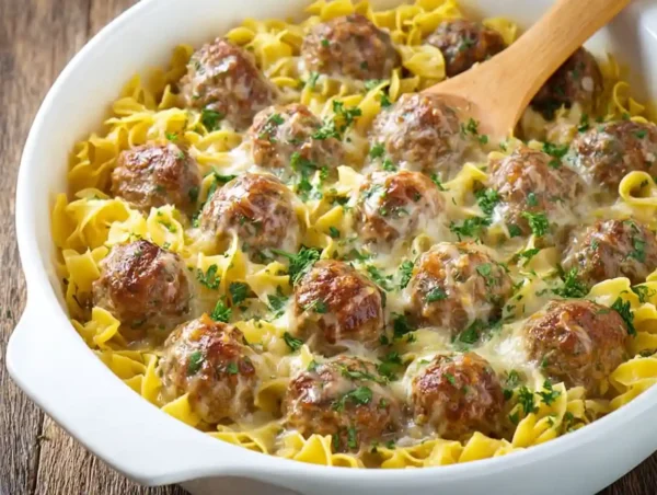 Delicious Swedish Meatball Pasta Bake topped with cheese and herbs