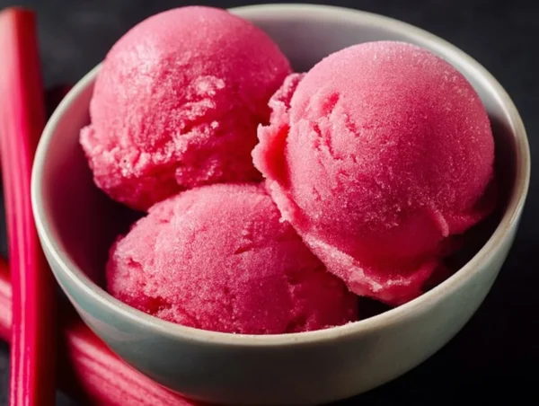 A vibrant bowl of rhubarb sorbet garnished with fresh mint leaves.