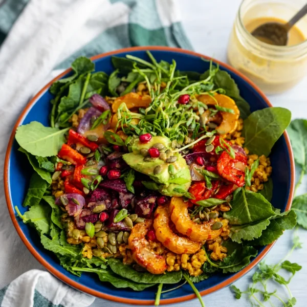 30-Minute Roasted Veggie Power Bowls with Maple Tahini Dressing A colorful bowl of roasted vegetables and quinoa drizzled with maple tahini dressing.