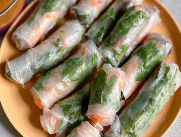Rice paper spring rolls served with peanut sauce, showcasing vibrant fresh ingredients.