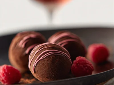 Delightful image of Handmade Chocolate Raspberry Truffles, showcasing the decadent dessert with pink chocolate drizzle.