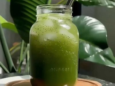 Matcha chia seed lemonade in tall glass over ice on marble countertop