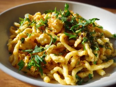 Homemade Spaetzle served with a creamy sauce and fresh herbs