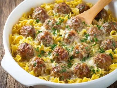 Delicious Swedish Meatball Pasta Bake topped with cheese and herbs