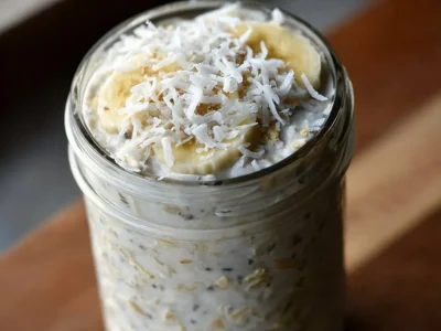 Delicious bowl of Banana and Coconut Overnight Oats topped with fruit and nuts