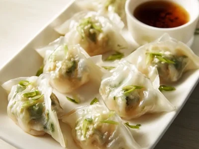 Cheesy shrimp scallion dumplings served on a plate.