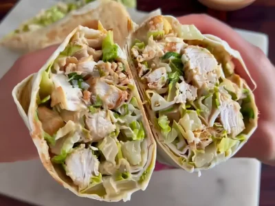 Chicken Caesar Wrap sliced open with visible grilled chicken and Caesar salad