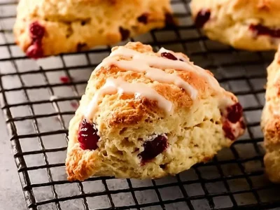 Freshly baked cranberry orange scones on a cooling rack.