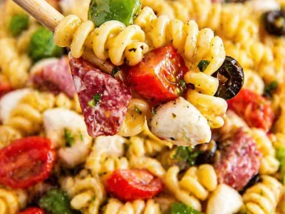 Cold pasta salad for BBQ with colorful vegetables and dressing.