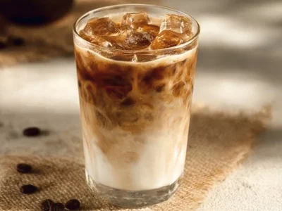 A delicious Iced Brown Sugar Vanilla Latte topped with whipped cream and caramel drizzle.