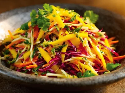 Colorful mango slaw with fresh vegetables in a bowl