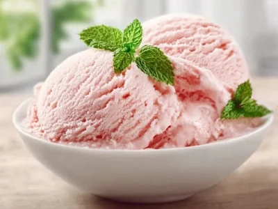 Delicious homemade rhubarb ice cream served in a bowl with fresh rhubarb garnish.