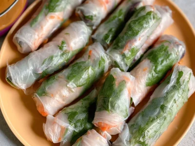 Rice paper spring rolls served with peanut sauce, showcasing vibrant fresh ingredients.