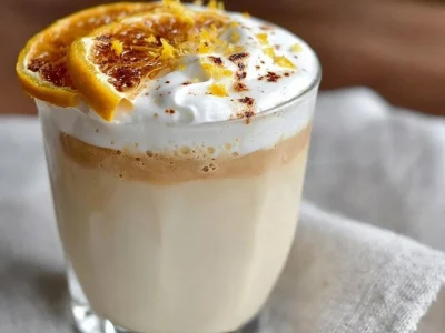 Delicious White Chocolate Orange Almond Latte in a coffee cup with orange zest garnish